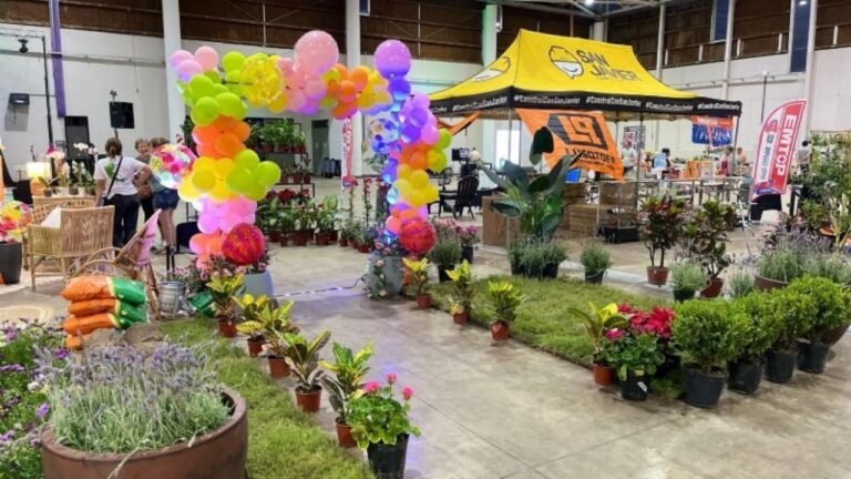 Vista de la Expo Jardín en el Predio Ferial de Catamarca, con stands de plantas y participantes en talleres.