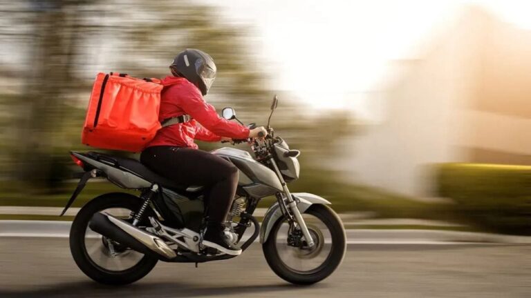 Repartidor de delivery en moto con mochila térmica en la calle