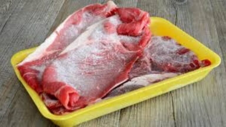 Carne cruda descongelándose sobre una mesada de cocina
