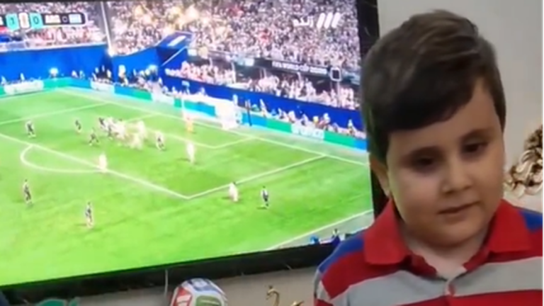 Niño ciego tocando maqueta de cancha de fútbol durante partido de Argentina