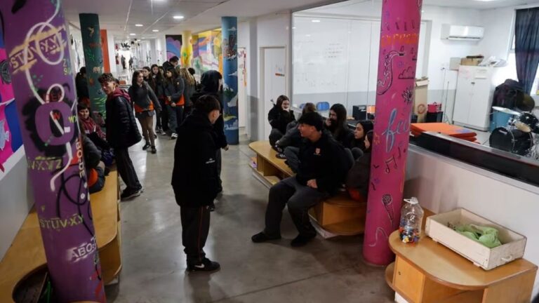Estudiantes secundarios usando celulares en un recreo escolar