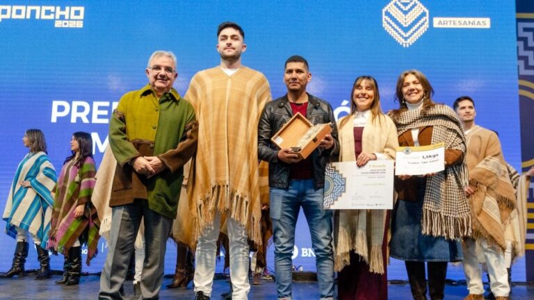 Saúl Suárez sosteniendo el poncho ganador del premio al Mejor Poncho 2026