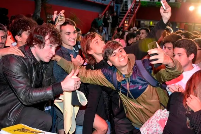Jóvenes en una plaza mirando sus teléfonos