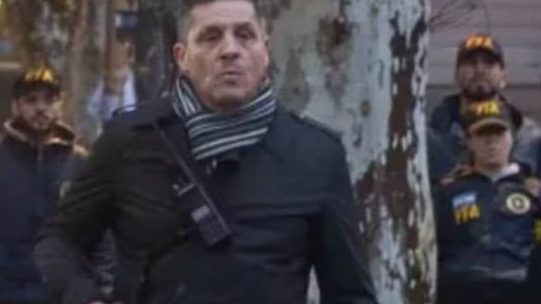 Fotografía de un agente de civil con arma larga durante la protesta frente al Congreso
