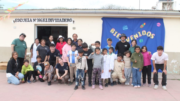 Estudiantes de Agrimensura de la UNCA junto a niños en la Escuela de El Divisadero