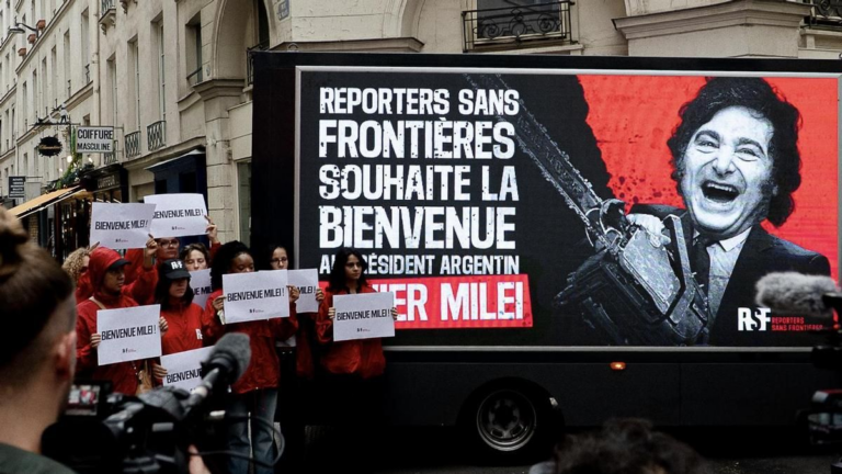 Camión de Reporteros Sin Fronteras con pantalla LED en París mostrando mensajes de Milei contra la prensa