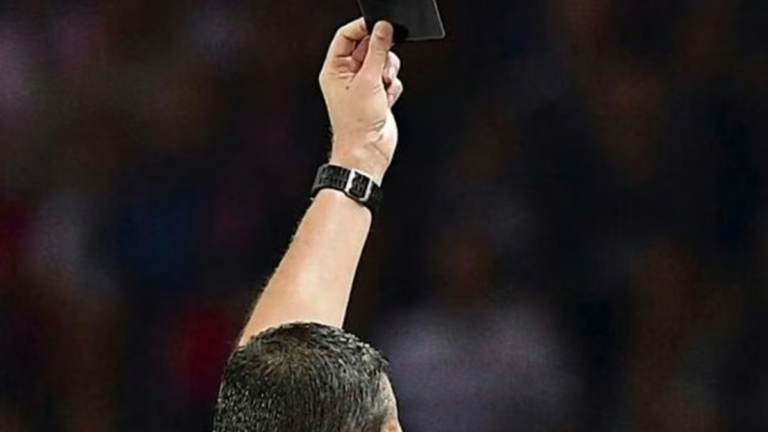 Árbitro mostrando una tarjeta negra durante un partido de fútbol juvenil en Rumania