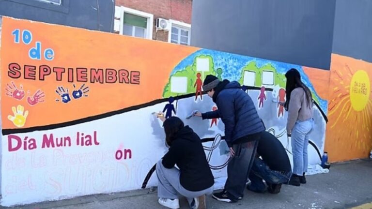 Muralistas trabajando en un mural sobre prevención del suicidio en Santa María, Catamarca