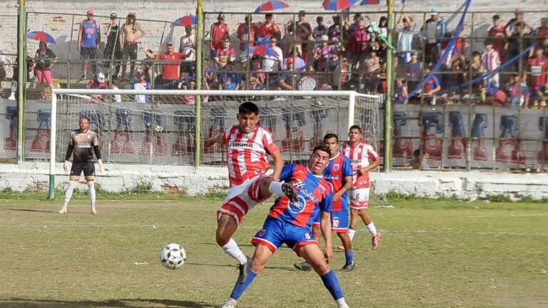 Estadio de fútbol con árbitros y jugadores durante un partido del Torneo Regional Federal Amateur