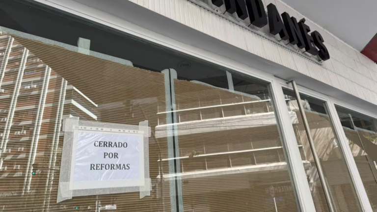 Fachada de una panadería Pandanés con persianas bajas y candado